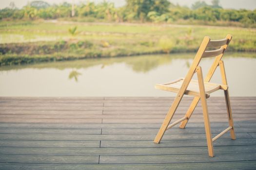 wooden chair on balcony terrace patio for resting near pond