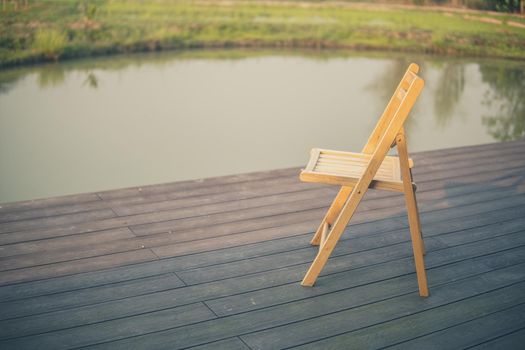 wooden chair on balcony terrace patio for resting near pond