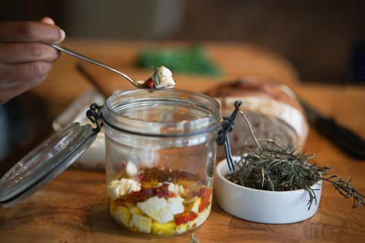 cottage farmer paneer cheese, sun dried tomatoes and rosemary marinated in olive oil in glass jar. vegetarian food