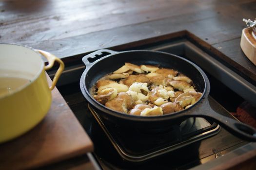 fried potatoes roasting in frying pan in kitchen