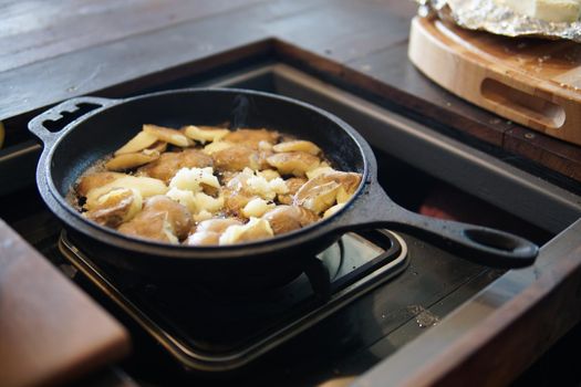 fried potatoes roasting in frying pan in kitchen