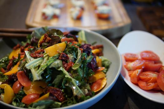 mixed vegetable salad with olive oil on wooden table