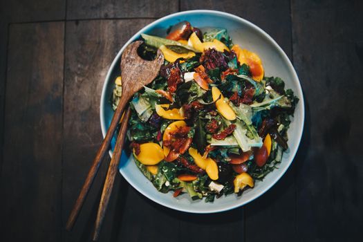 mixed vegetable salad with olive oil on wooden table