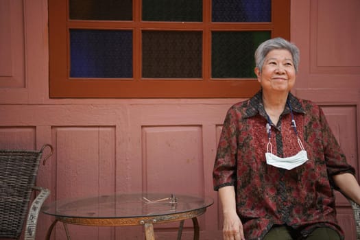 asian old elder woman elderly female relaxing resting on balcony terrace. senior leisure lifestyle