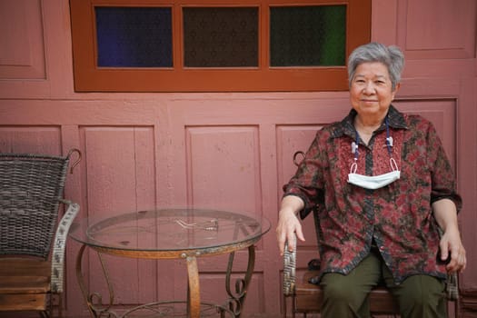 asian old elder woman elderly female relaxing resting on balcony terrace. senior leisure lifestyle