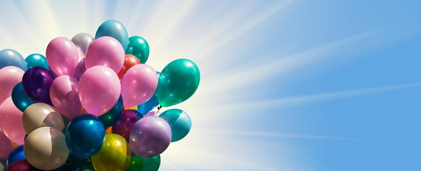 Bunch of colorful balloons against blue sky with sun light