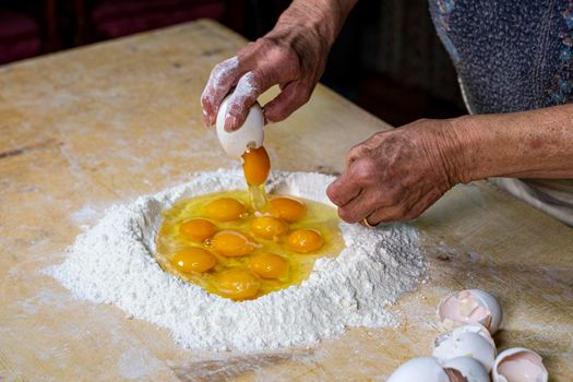 grandmother preparing eggs for homemade pasta dough