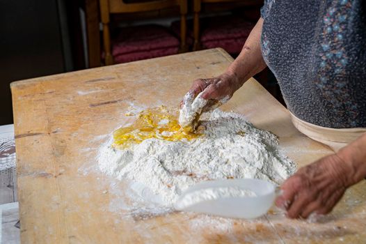 grandmother preparing homemade dough dough with flour and eggs