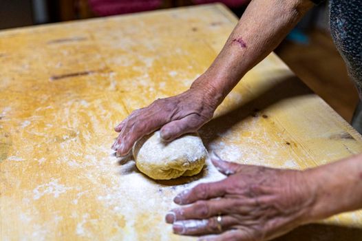 grandmother preparing homemade dough dough with flour and eggs