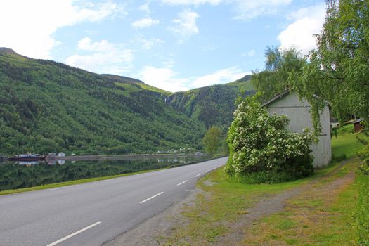 Picturesque spring Norway landscape with asphalt road travel in mountains