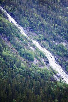 High waterfall in mountain forest near Rjukan, Hardanfervidda, Norway