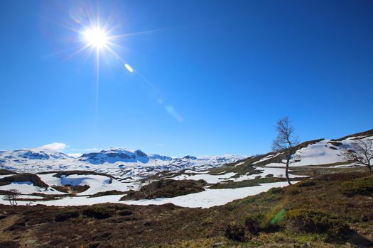 Spring valley landscape with mountains and melting snow, Norway