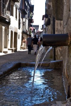 Close-up of a drinking fountain in an old street at an old medieval street on a sunny day