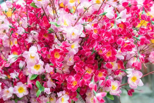 artificial multicolored flowers close up as background. High quality photo