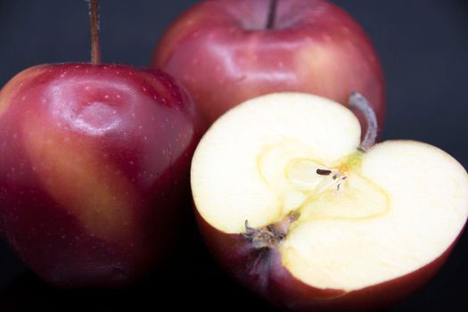 Red ripe apples on a black background.Cut red apple.Half an apple.