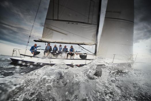 Russia, St.Petersburg, 05 September 2020: Participants of a sailing regatta on the sailboat, pull ropes, water splashes in the foreground, focus on splashes. High quality photo
