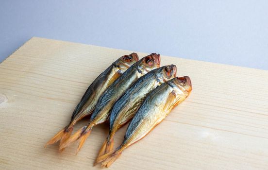 Horse mackerel fish, cold smoked. Smoked fish close-up on a wooden background .Food industry.