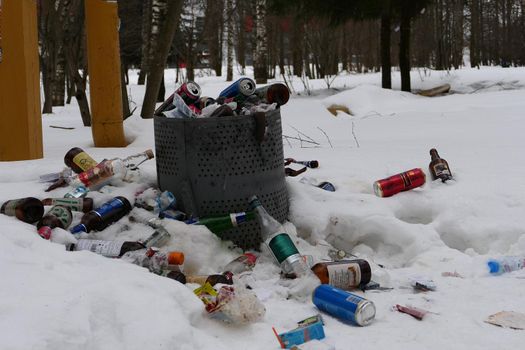 Garbage dump in the park. Dirt and pollution with plastic, aluminum and glass bottles. High quality photo