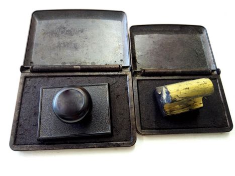 Vintage stamps in boxes with a wooden handle on a white background.