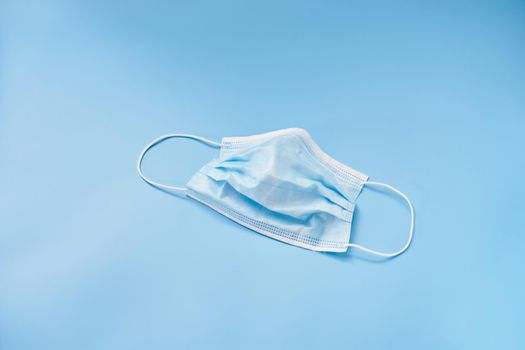 Isolated medical face mask on a blue background. Personal protective equipment. High quality photo