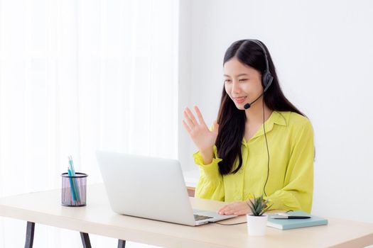 Young asian business woman using laptop computer for video conference online with social distancing, businesswoman working with video call, new normal, communication and work from home concept.