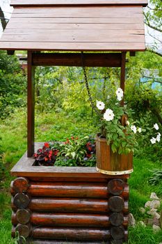 Rural landscape with flowers in a wooden bucket.