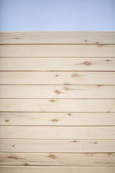 The background is a wall made of wooden beams.Texture for your design. Wooden beam and board. Background for still life. Beautiful wood texture. 