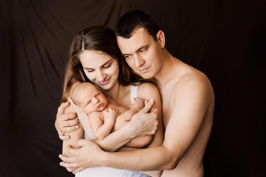 Newborn baby sleeping in her parents' arms. High quality photo
