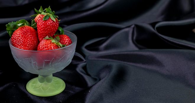 cup banner of ripe strawberries on black background