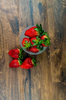 cup of ripe strawberries on wooden background