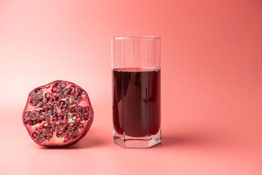 a glass of pomegranate juice and pomegranates on a red background. High quality photo