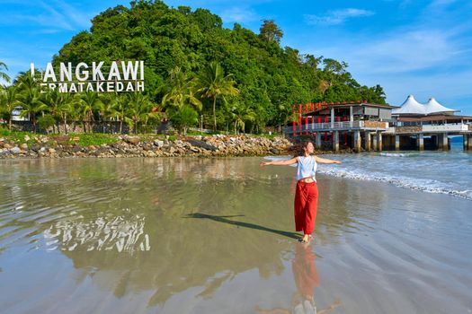 happy tourist woman enjoy travel on the central beach in Langkawi tropical island.