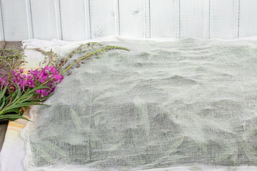 Harvesting fireweed for tea - drying spread leaves and flowers under a thin cloth.