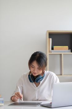 Young asian woman student study at home using laptop and learning online.