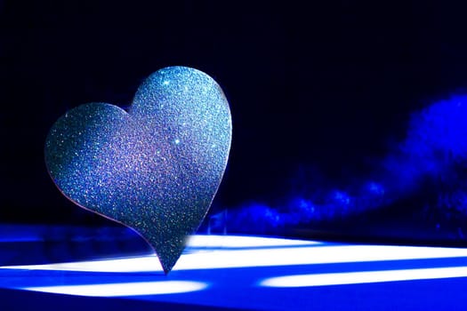 Golden shiny heart on black background
