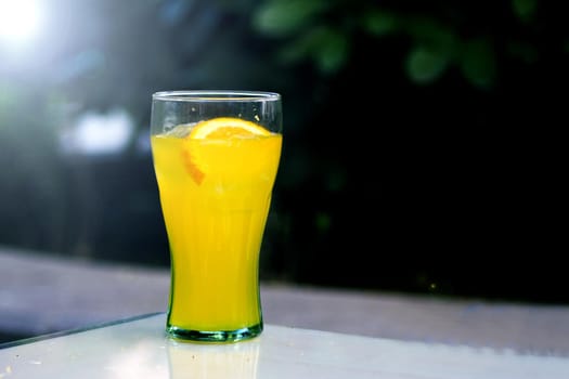 Orange soda in a crystal glass with a piece of natural orange. No people