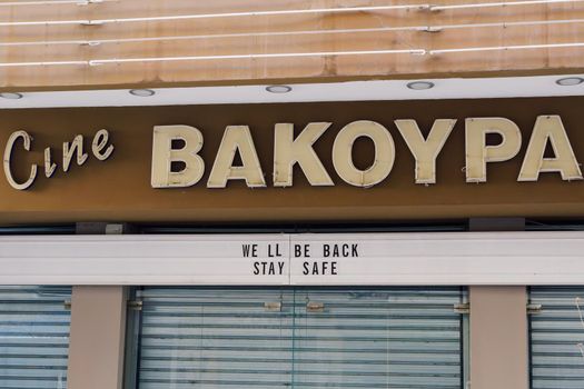 Closed due to covid-19 measures auditorium entrance in Greece, with message on facade.