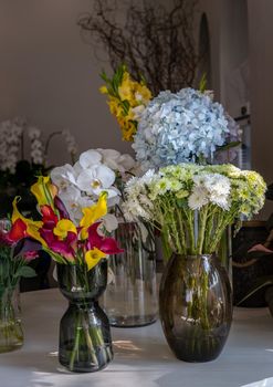 Beautiful bouquet of flowers in Assorted many different glass vases in flower shop. Home decor. Selective focus.