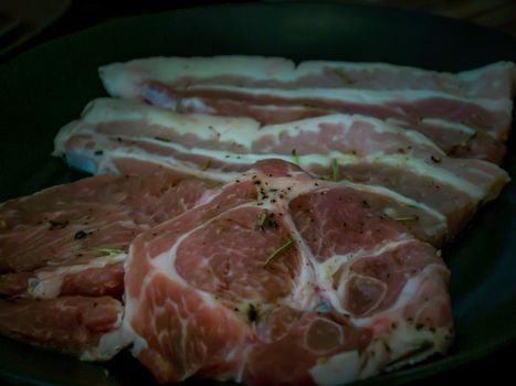 Ribeye steak with rosemary and Streaky pork bacon on plate ready ready grill on stove serve. Korean style barbecue. No focus, specifically.