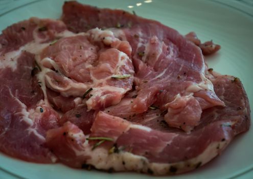 Pork meat with rosemary on plate ready ready grill on stove serve. Korean style barbecue. No focus, specifically.