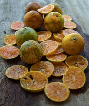 Fresh orange fruits on the old wooden table. Tangerine Phurua species, Juicy orange sour and sweet, healthy fruits, Selective focus.