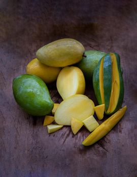 Variety of fresh mango on the old wooden table. fruits background, healthy fruits, Dark tone, Copy spce, Selective focus.