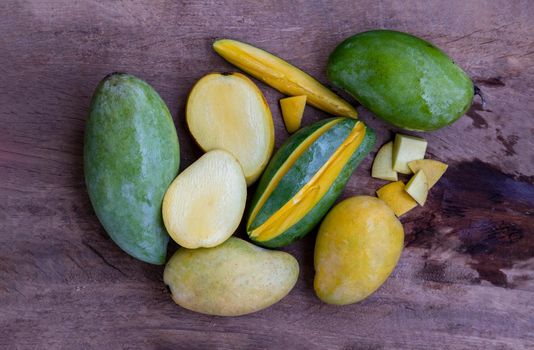 Variety of fresh mango on the old wooden table. fruits background, healthy fruits, Copy spce, Selective focus.