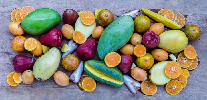 Variety of fresh assorted fruits on the old wooden table. Assorted fruits colorful background, healthy fruits, Selective focus.