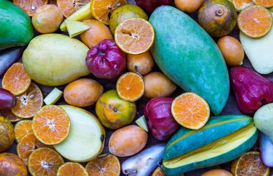 Variety of fresh assorted fruits on the old wooden table. Assorted fruits colorful background, healthy fruits, Selective focus.