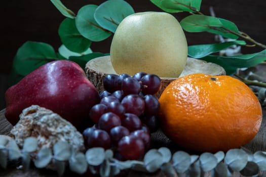 Variety of fresh assorted fruits on the old wooden table. Assorted fruits colorful background, healthy fruits, Dark tone, Selective focus.