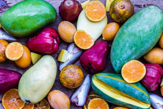 Variety of fresh assorted fruits on the old wooden table. Assorted fruits colorful background, healthy fruits, Selective focus.