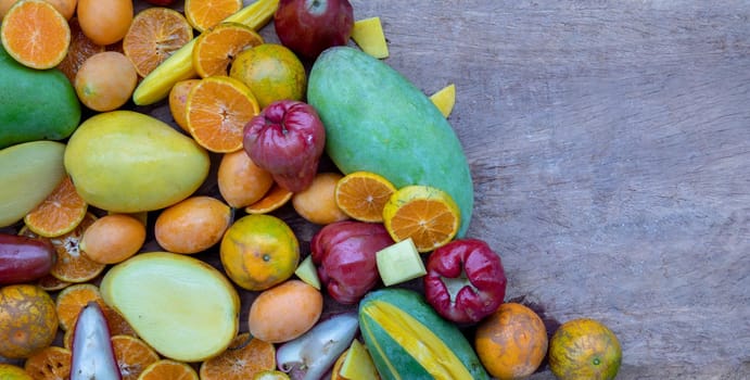 Variety of fresh assorted fruits on the old wooden table. Assorted fruits colorful background, healthy fruits, Copy spce, Selective focus.