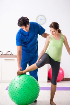 Fitness instructor helping sportsman during exercise