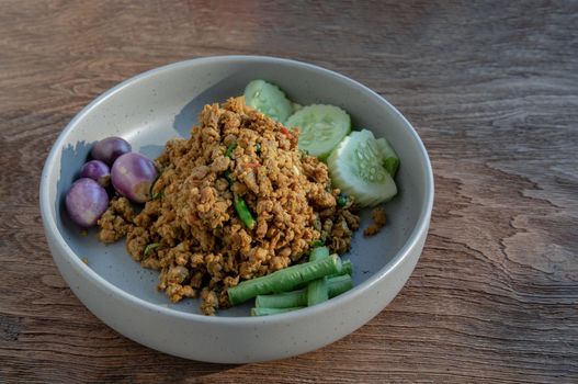 Southern Stir-Fried Pork with Yellow Curry Paste Served with Purple eggplant, Cucumber and Yard long bean. Selective focus.